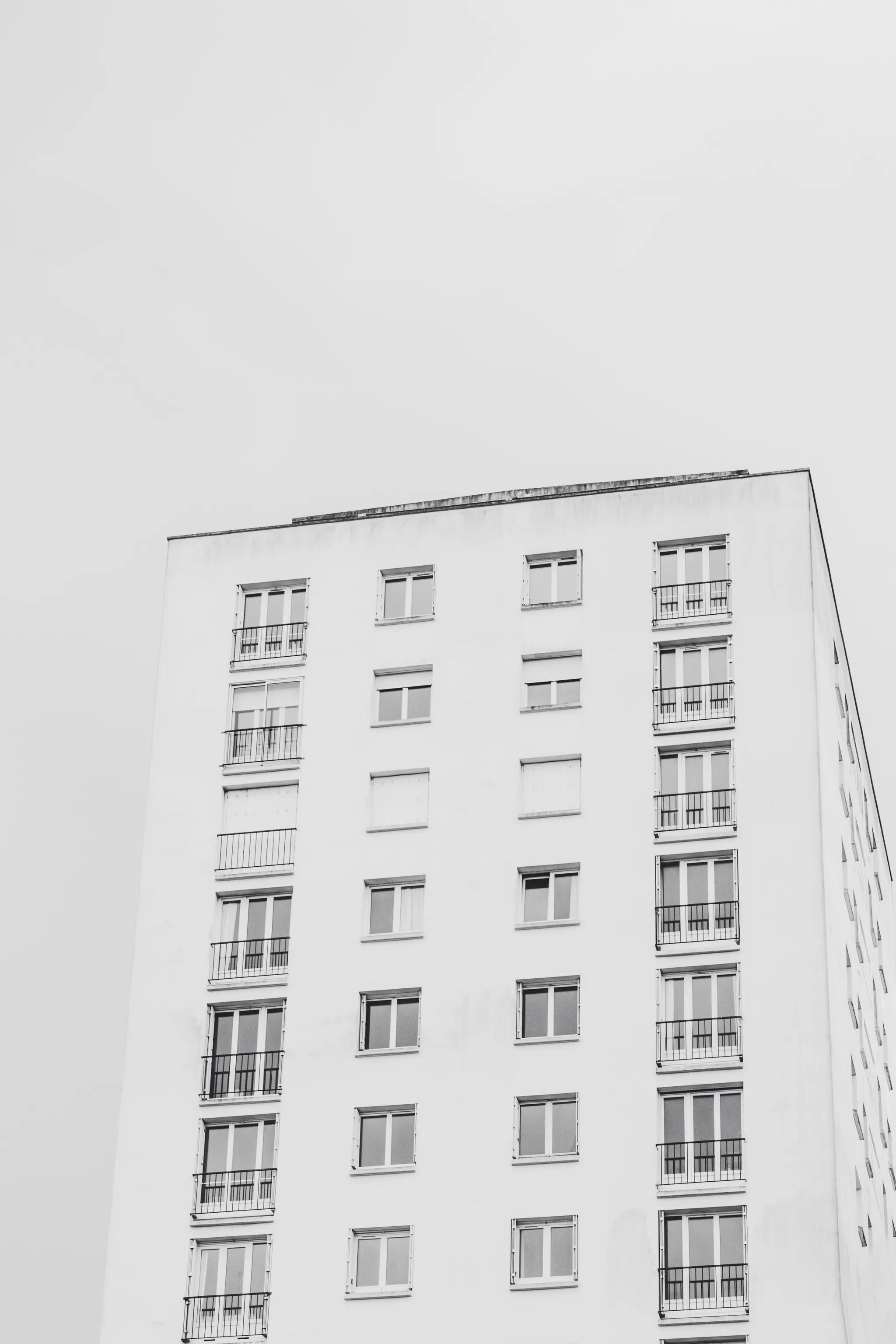 White post-war apartment tower against a pale sky, black and white